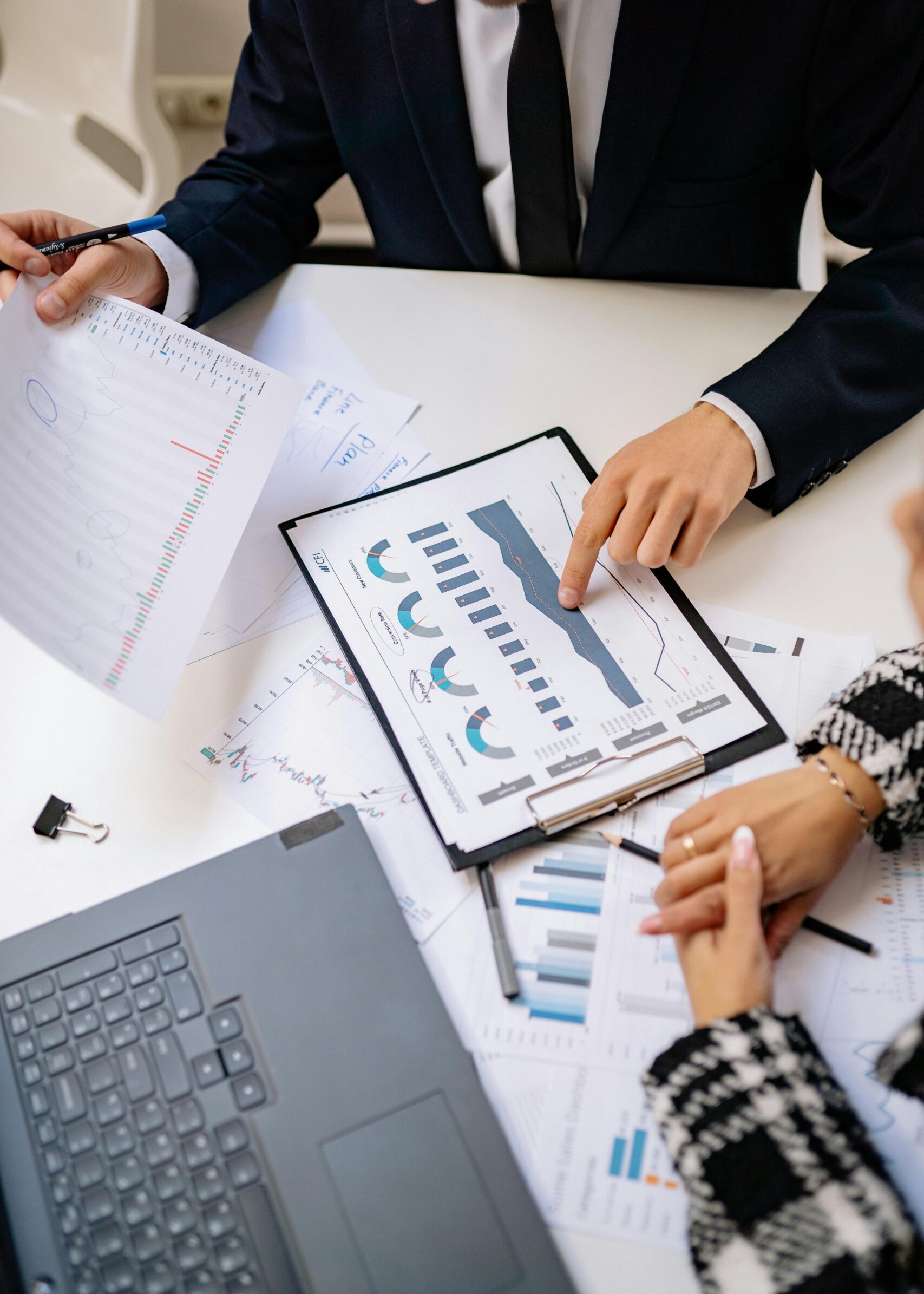 Teamwork in a modern office setting with charts and laptops showcasing collaboration.